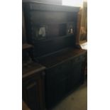 A dark oak dresser with glass panel doors to front