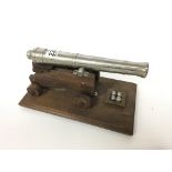 A heavy model wood and metal cannon on wooden base