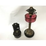 A Victorian brass column oil lamp with red reservo
