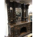 A large and impressive Victorian oak side board profusely carved , the mirrored back Above drawers