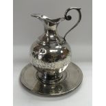 An Italian white metal jug and dish with a hand ha