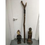 A tribal chanting stick and two carved wood figures