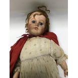 A bisque headed doll in the form of red ridding ho