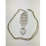 An unusual silver pendant in the form of a love spoon on a chain.