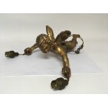 A gilded composition hanging light in the form of a winged cherub.