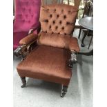 A Victorian open arm chair with brown button back