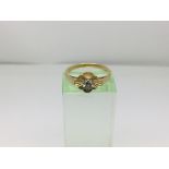 An 18ct gold ring set with a small diamond, approx