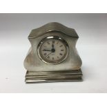 A small silver case mantle clock with quartz movem
