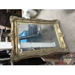 A large gilt and glazed picture frame.
