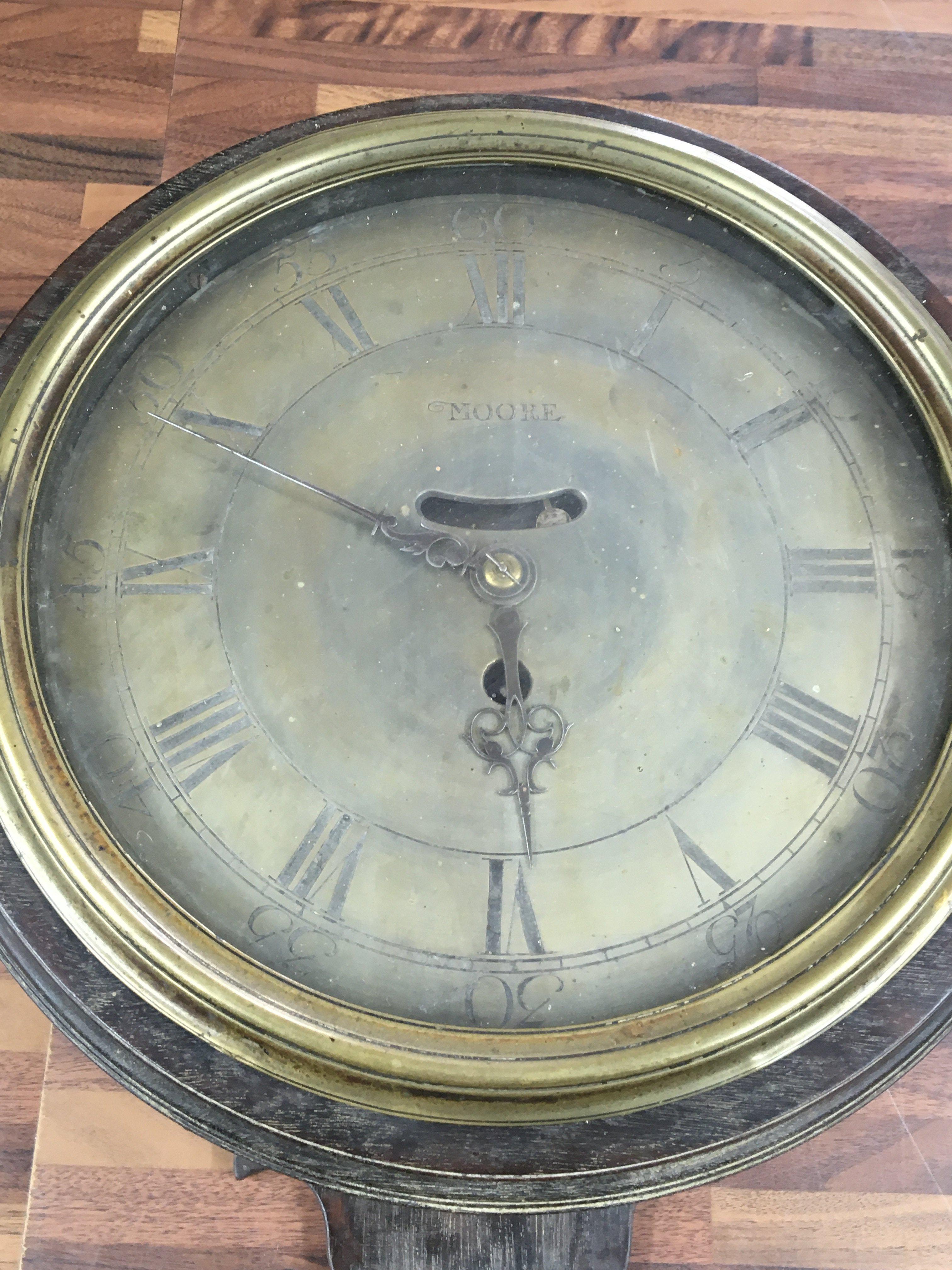 A 19th century oak case circular wall clock with verge movement. The brass dial with Roman