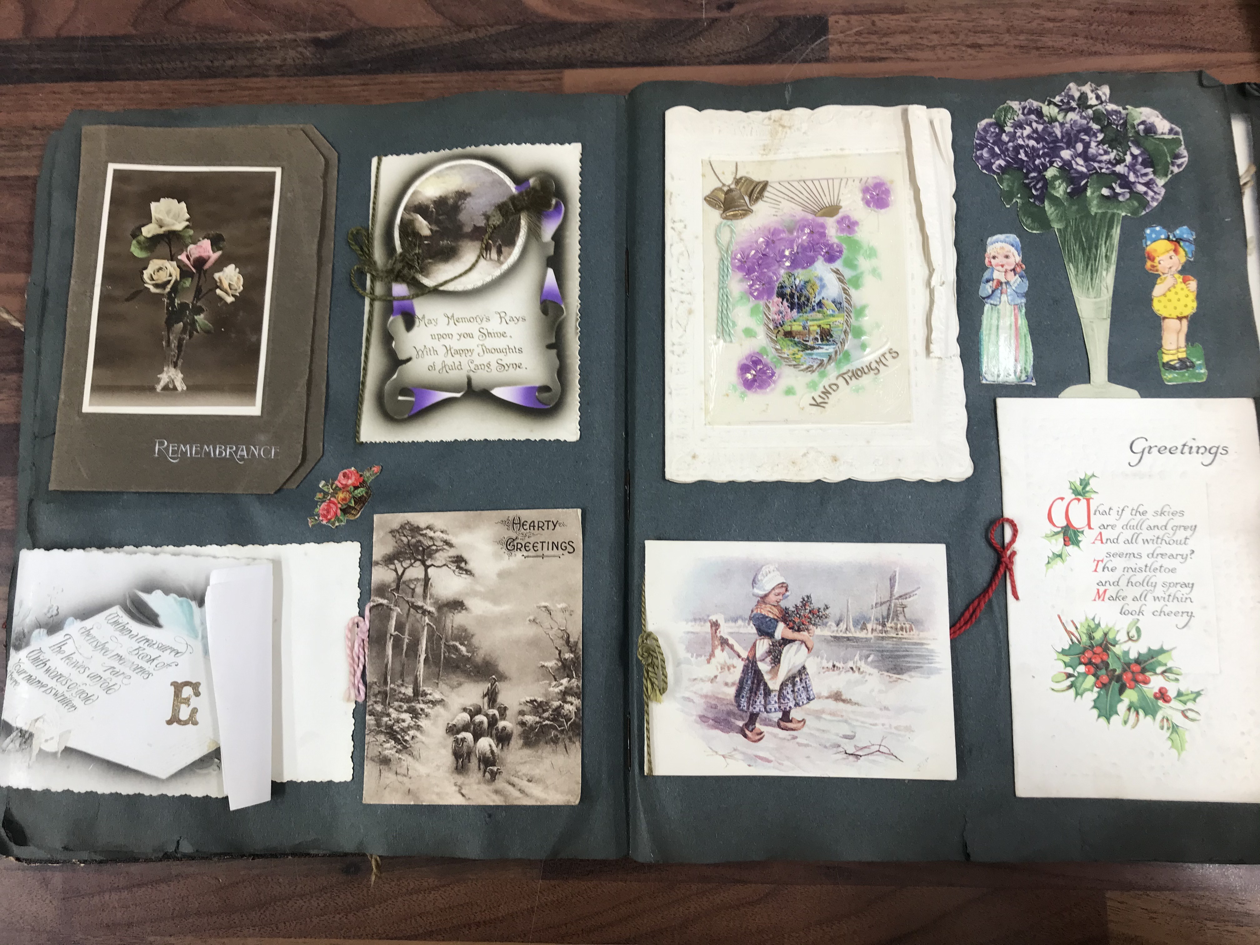 An early 20thC scrap album and greetings cards.