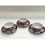 Three Oriental tea bowls and saucers with blue, ma