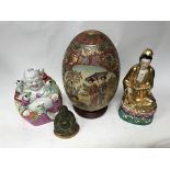 A large Chinese porcelain egg, porcelain figure of Guanyin and a figure of the happy Buddha.