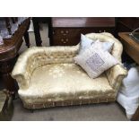 A miniature silk upholstered chaise lounge.