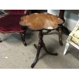 A Victorian mahogany tripod legged wine table.