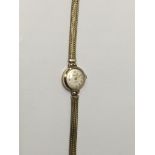 A ladies wrist watch with 9 ct gold Case and strap