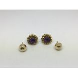 A pair of 9ct gold earrings set with amethyst plus