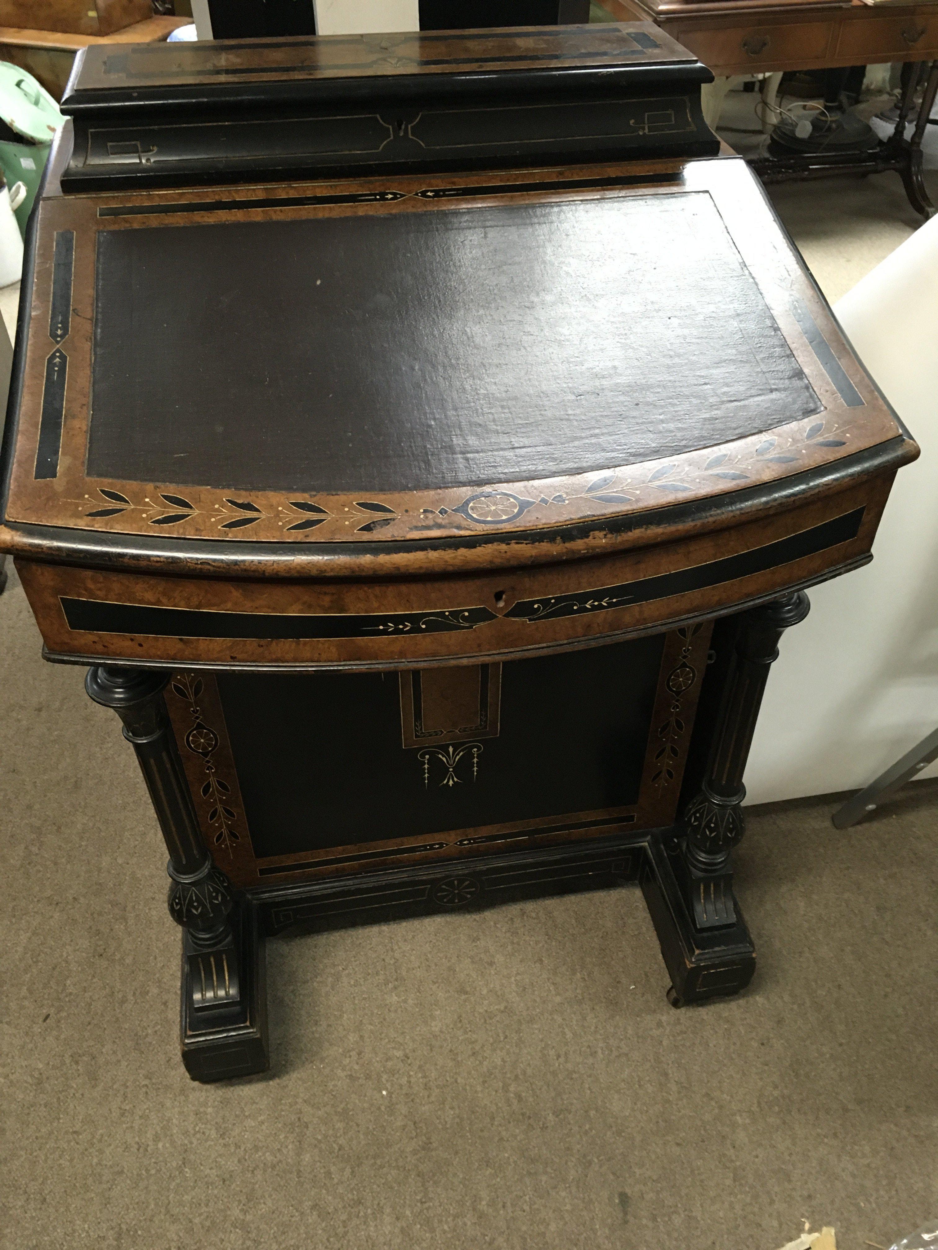 A Victorian danvenport ebonised with walnut banding the sloping front above side drawers