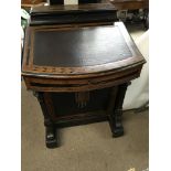 A Victorian danvenport ebonised with walnut banding the sloping front above side drawers