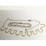 A gold horseshoe design necklace, a/f, and matchin