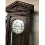 A walnut Vienna wall clock the dial with Roman numerals and visible pendulum.