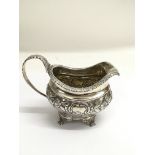 A Georgian, London silver cream jug, repousse deco