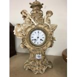 A Victorian pottery clock case young and old with classical influence the enamel dial with Roman