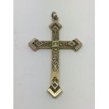 A yellow metal crucifix set with green stones, approx 8.5g.