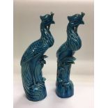 A pair of turquoise blue ceramic figures of peacoc