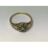 A unmarked ring inset with green and clear gemston