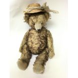 A large vintage plush teddy bear with long arms an