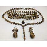 A collection of tiger's eye jewellery comprising two necklaces, pendant and a pair of earrings.