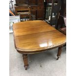 A Victorian mahogany wind out dining table with re