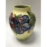 A moorcroft vase decorated with flowers on a yello