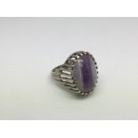 A silver ring set with a purple stone, approx size