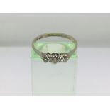 An 18ct white gold and three stone diamond ring, a