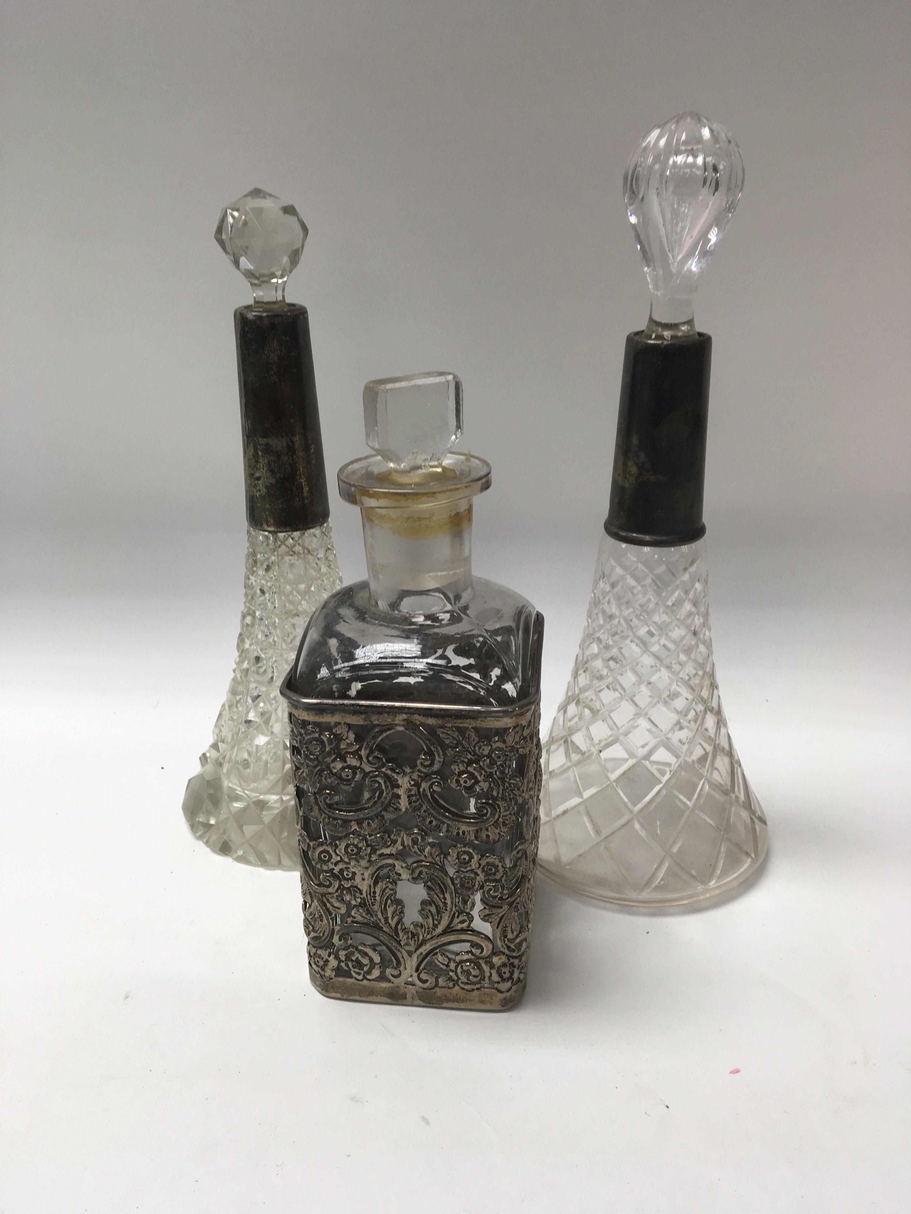 Two glass perfume bottles with silver collars and