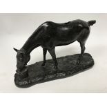 A patinated bronze model of a horse drinking after