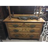 A walnut chest of drawers with ornate handles on c