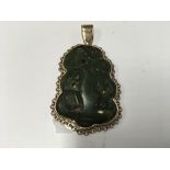 A heavy 9ct gold mounted carved jade Tiki pendant