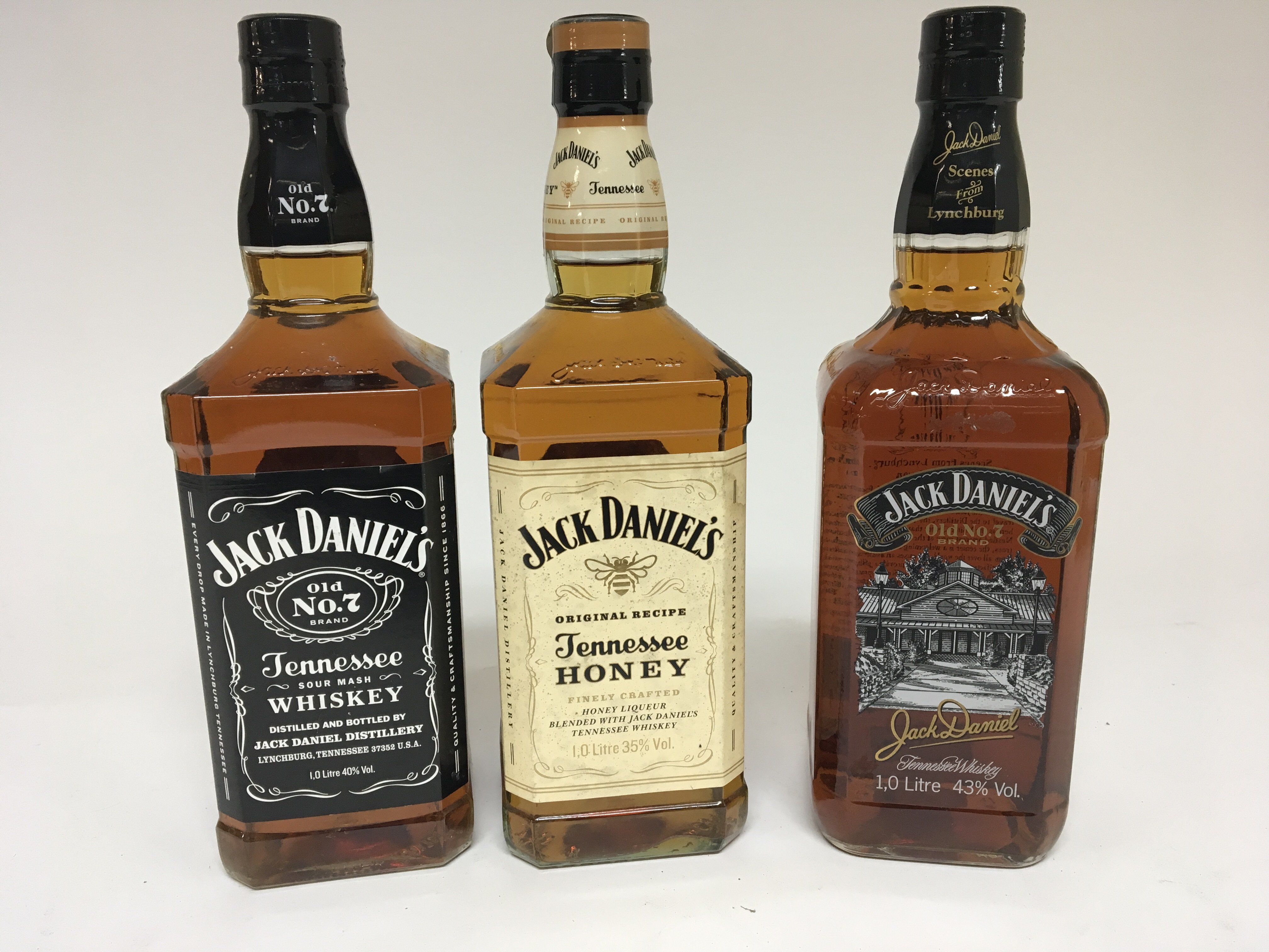 Three bottles of Jack Daniels Tennessee Whisky Old no 7 and Tennessee Honey all one litter bottles .