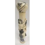 A Chinese carved bone parasol handle decorated with mermaids.