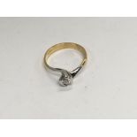A 18 ct white and yellow gold ring inset with a single diamond.