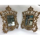 A pair of heavy ornate gilt painted mirrors.