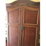 A mahogany wardrobe with a pair of doors and drawer under.