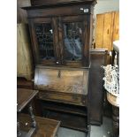 A small arts and crafts oak bureau bookcase with leaded glass doors. 172cm x 71cm