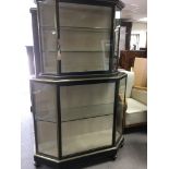 An ebonised display cabinet With glazed doors and sides enclosing glass selfs on turned feet .115 cm
