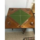 A Edwardian mahogany envelope card table the fold over top enclosing a green baize on square