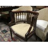 A Edwardian mahogany open armchair on square tapering legs .