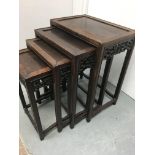 A nest of four Chinese occasional tables the square tops with carved surrounds on square tapering